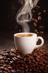 A steaming white ceramic cup of hot coffee resting on a large pile of roasted coffee beans with beans falling dynamically in the dark background.