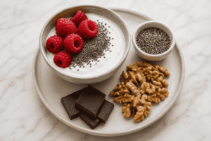 Low carb sweet snacks with Greek yogurt, raspberries, chia seeds, walnuts, and dark chocolate